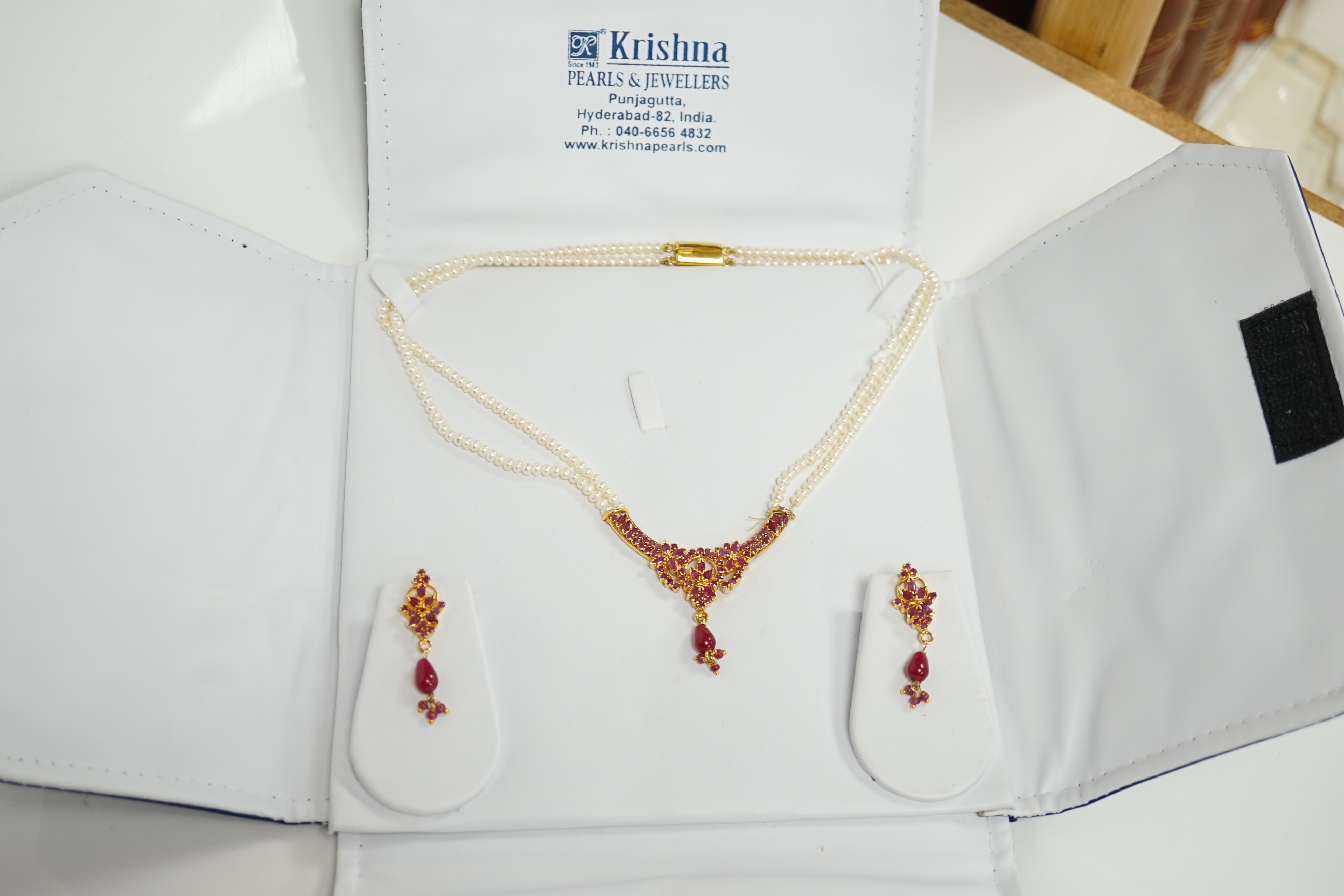 A recent Indian gilt metal and freshwater pearl and ruby cluster set twin strand necklace, 46cm and a pair of matching drop earrings. Condition - fair to good